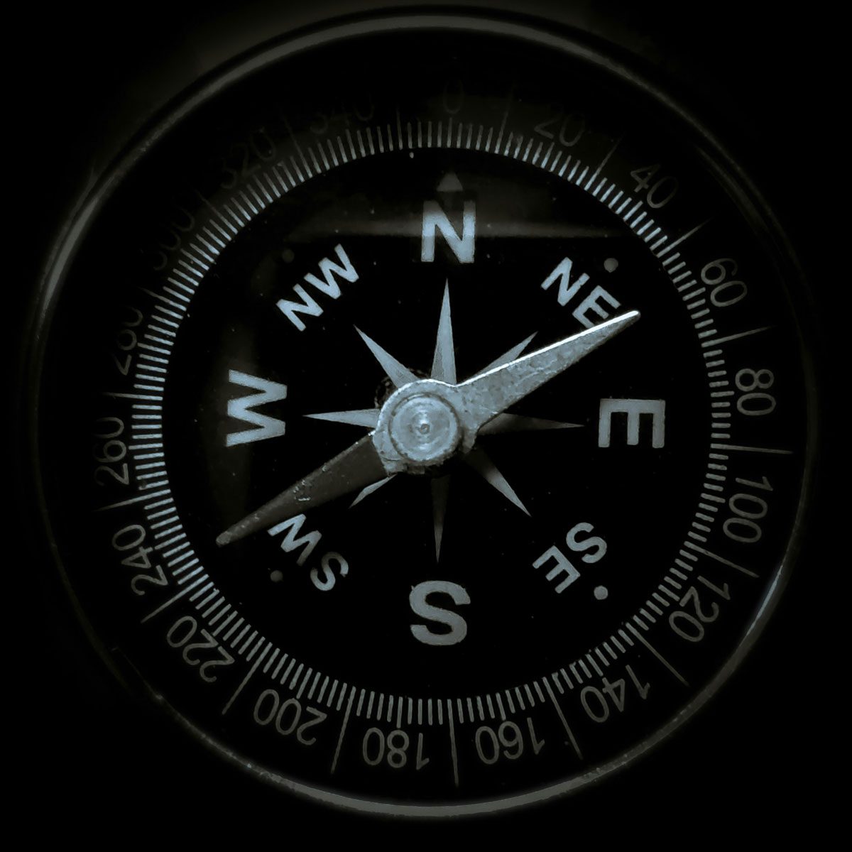 Close up of a compass with a black dial face