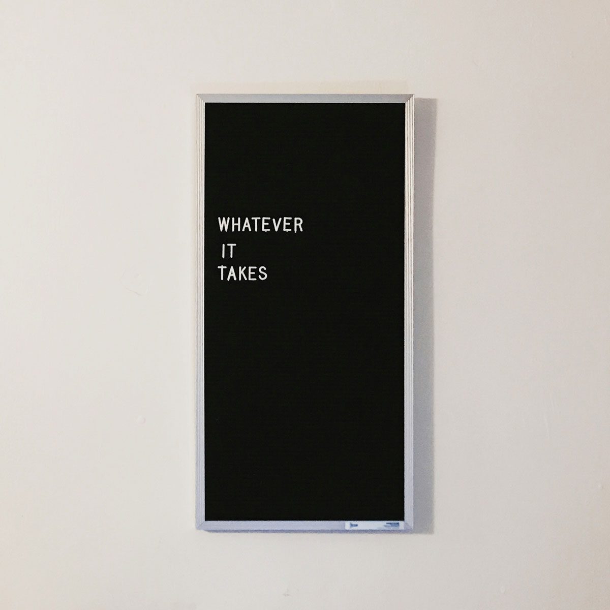Black letter board with white letters that spell "Whatever it takes"